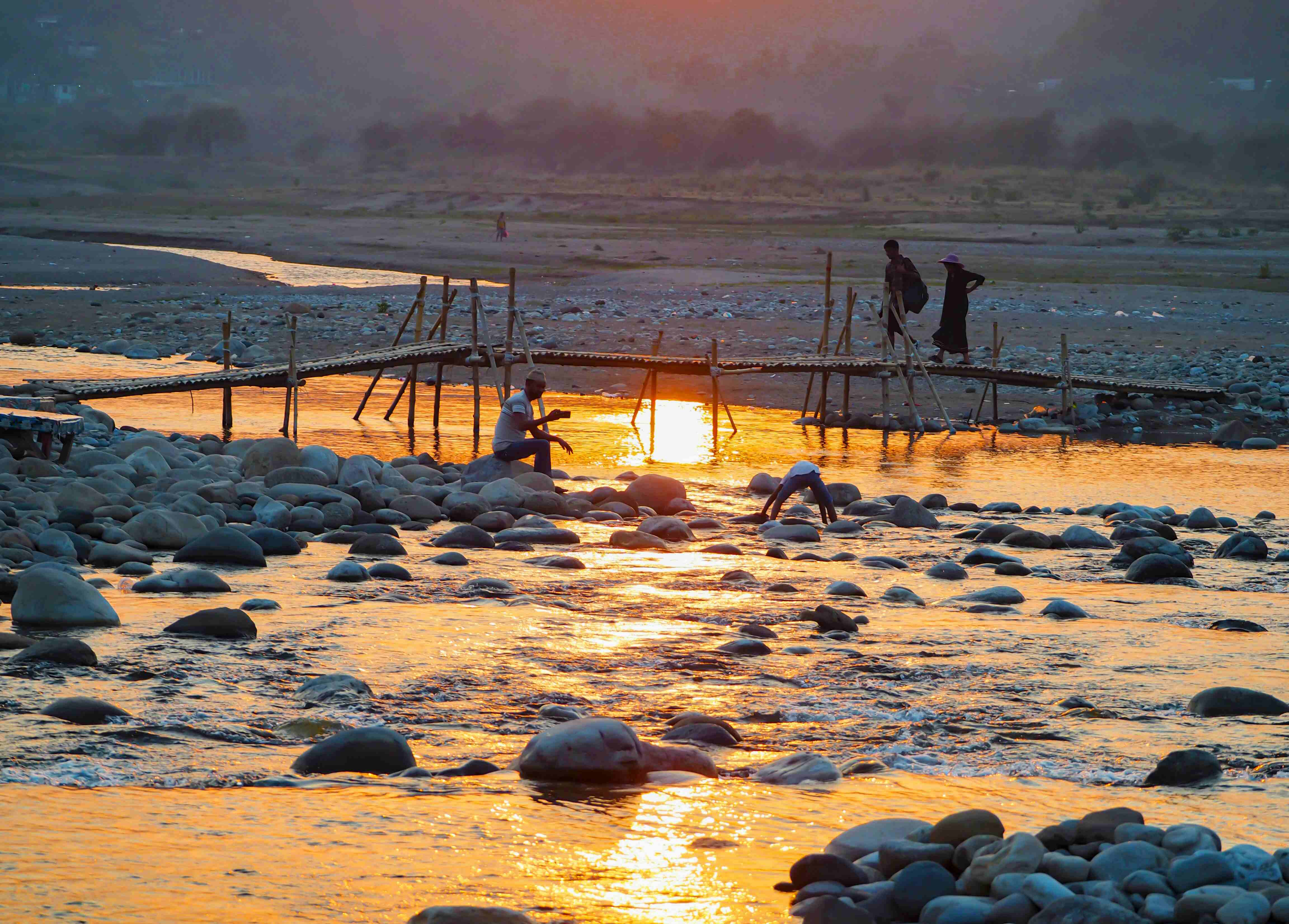 Sunset at Jaflong Golden sunset over Jaflong River with local people collecting stones